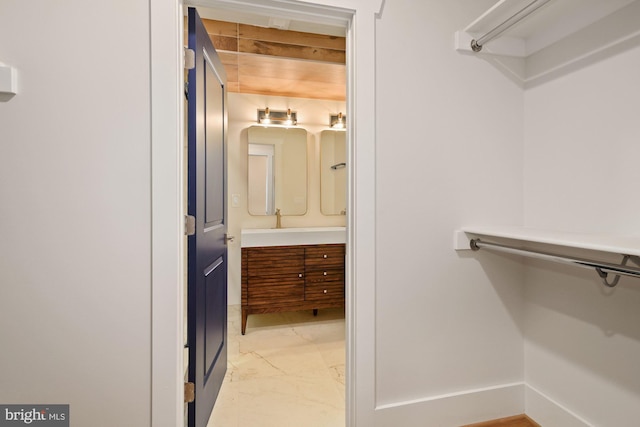 walk in closet featuring marble finish floor