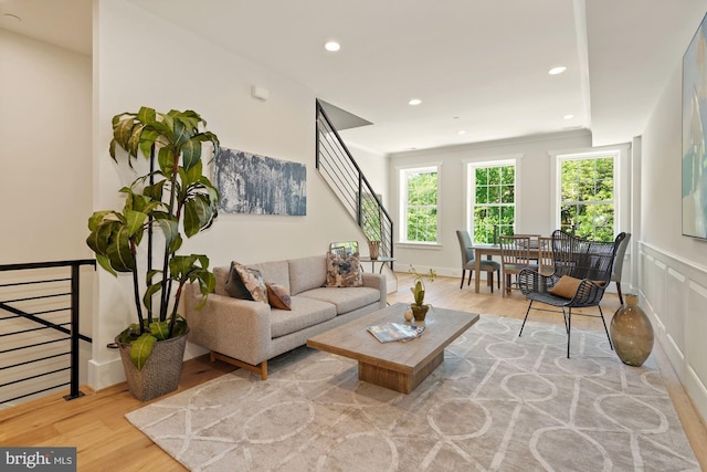 living area with recessed lighting, wood finished floors, and stairway