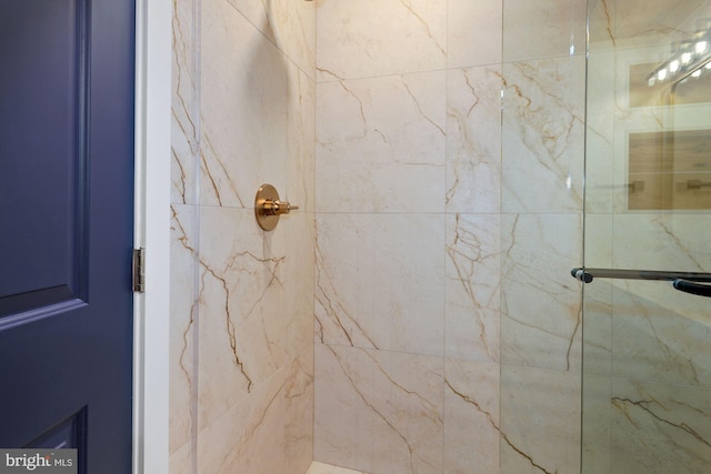 bathroom featuring a marble finish shower