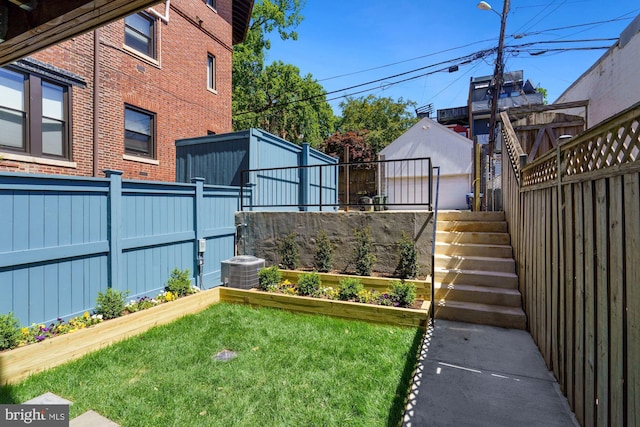 view of yard with central air condition unit, a fenced backyard, and a vegetable garden