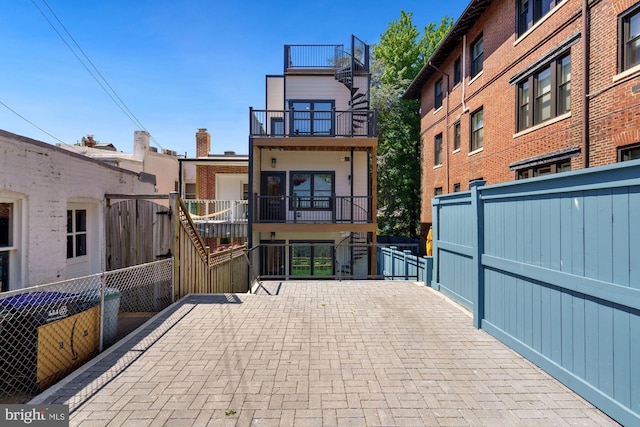 exterior space with stairs, fence, and a balcony