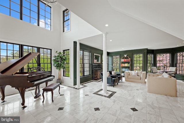 interior space with marble finish floor, decorative columns, recessed lighting, and a towering ceiling