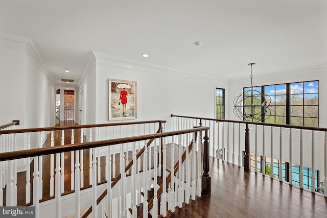 hallway with an inviting chandelier, crown molding, recessed lighting, and an upstairs landing