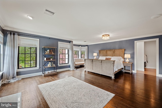 bedroom featuring multiple windows, ornamental molding, and visible vents