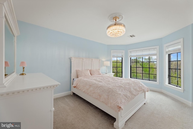 bedroom with baseboards, light carpet, and visible vents