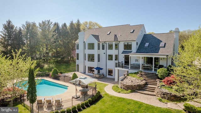 back of house featuring fence, a patio, a chimney, a fenced in pool, and stairway