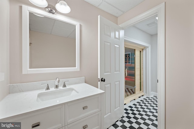 bathroom with tile patterned floors, visible vents, vanity, and a paneled ceiling