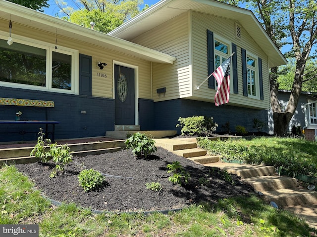 entrance to property featuring brick siding
