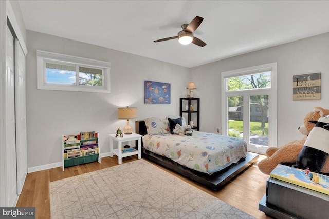 bedroom with baseboards, ceiling fan, access to exterior, and wood finished floors