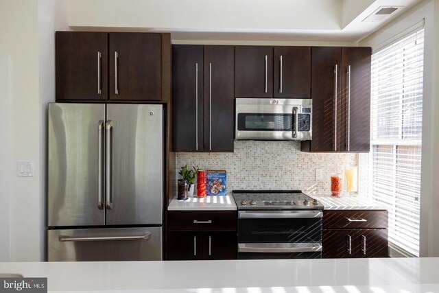 1421 Florida Ave NW Unit 5, Washington, DC 20009 - kitchen featuring dark brown cabinetry, appliances with stainless steel finishes, light countertops, backsplash, and visible vents