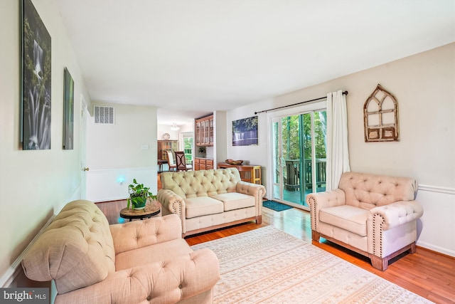 living room featuring visible vents and wood finished floors