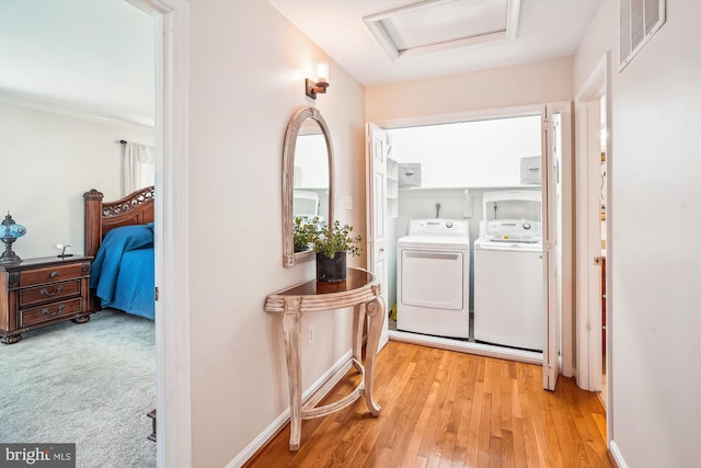laundry area featuring visible vents, laundry area, wood finished floors, attic access, and washer and clothes dryer