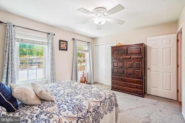 carpeted bedroom with ceiling fan and a closet