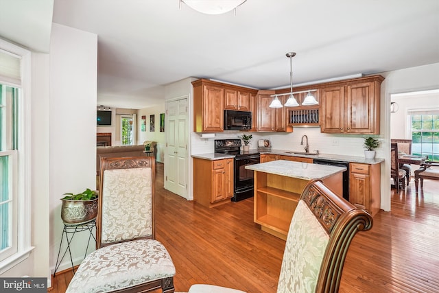 kitchen with open shelves, a sink, wood finished floors, tasteful backsplash, and black appliances