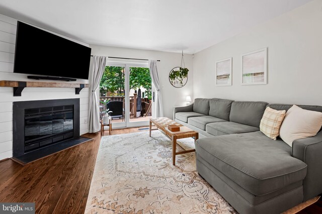 living area featuring wood finished floors and a fireplace with flush hearth