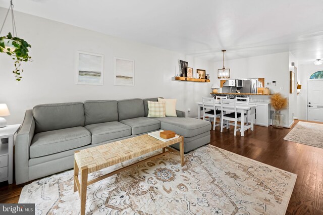 living area with a chandelier and dark wood-type flooring