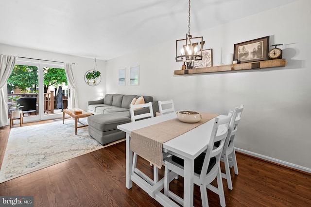 dining area with dark wood-type flooring, a chandelier, and baseboards