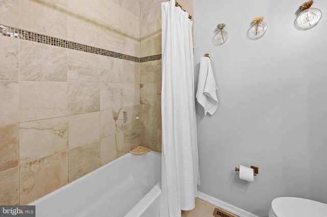 full bath with baseboards, toilet, and shower / bath combo with shower curtain