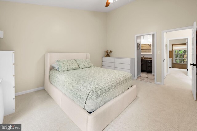 bedroom with carpet floors, baseboards, ceiling fan, and connected bathroom
