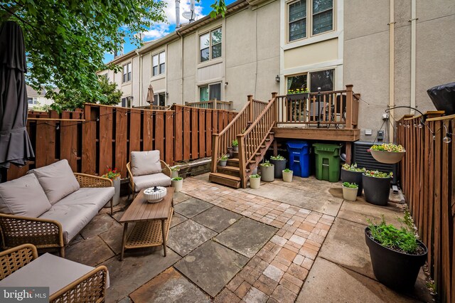 view of patio / terrace featuring fence, outdoor lounge area, a deck, and stairs