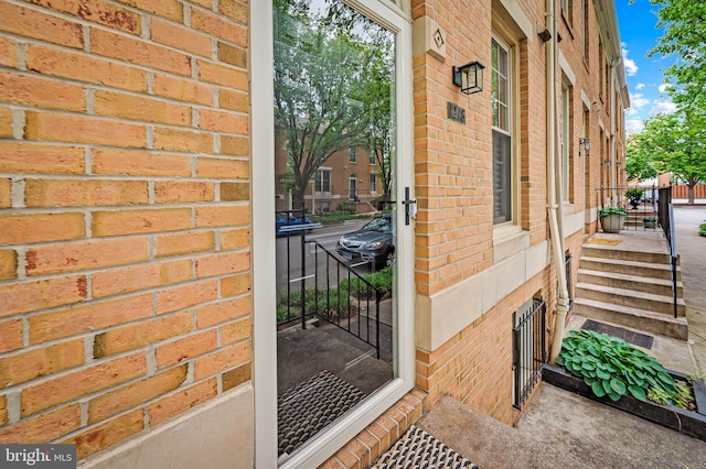 doorway to property with brick siding