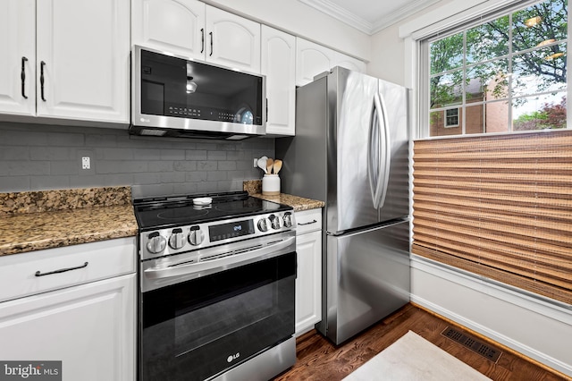 kitchen with appliances with stainless steel finishes, crown molding, dark wood-style floors, decorative backsplash, and white cabinets