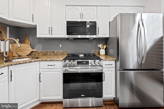 kitchen featuring stainless steel appliances, a sink, and white cabinetry