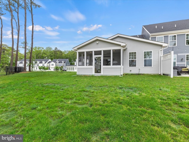 35040 Dundee St Unit 133, Frankford, DE 19945 - rear view of house with a sunroom, fence, and a lawn