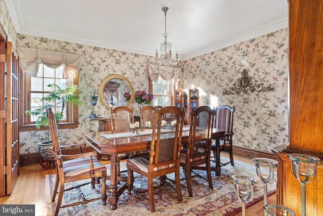 dining space featuring wood finished floors, a notable chandelier, a wealth of natural light, and wallpapered walls