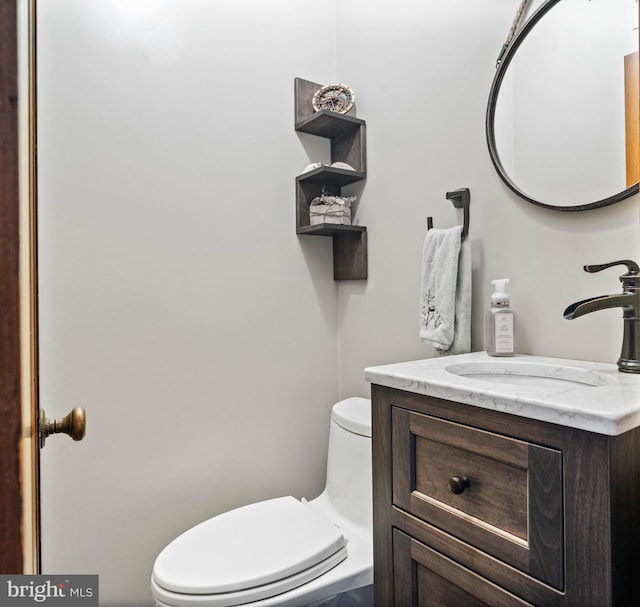 half bathroom with toilet and vanity