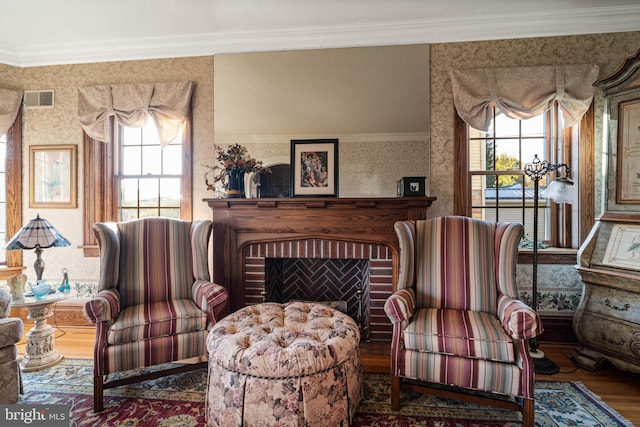 sitting room featuring visible vents, wood finished floors, a healthy amount of sunlight, and wallpapered walls