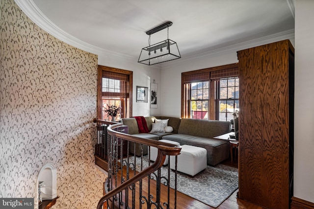 living area with crown molding, plenty of natural light, and wood finished floors