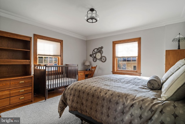 bedroom with ornamental molding, wood finished floors, and multiple windows