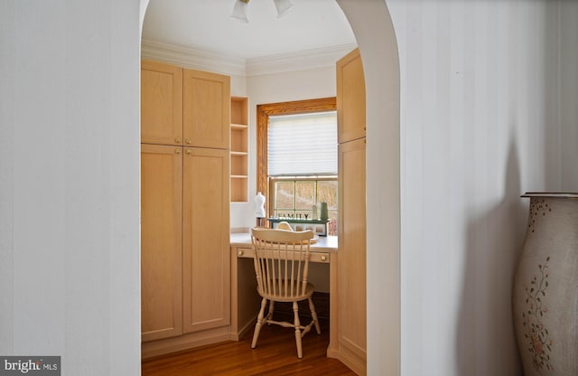 corridor featuring crown molding, arched walkways, and wood finished floors