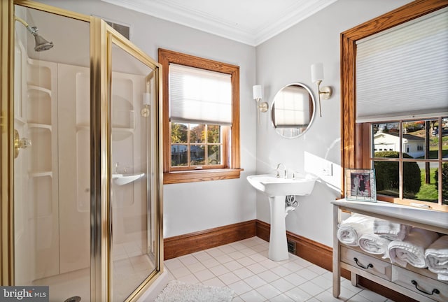 bathroom featuring tile patterned flooring, baseboards, crown molding, and a stall shower