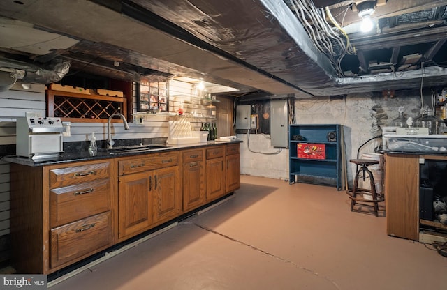 basement featuring indoor wet bar, a sink, and electric panel