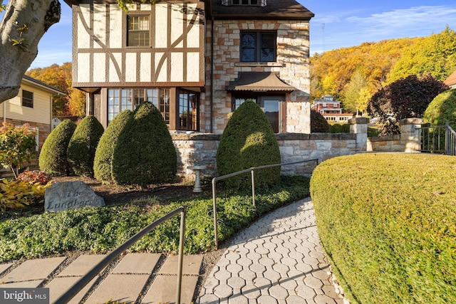 english style home featuring stone siding