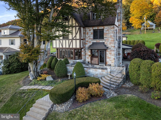 view of front of property featuring a front lawn and stone siding