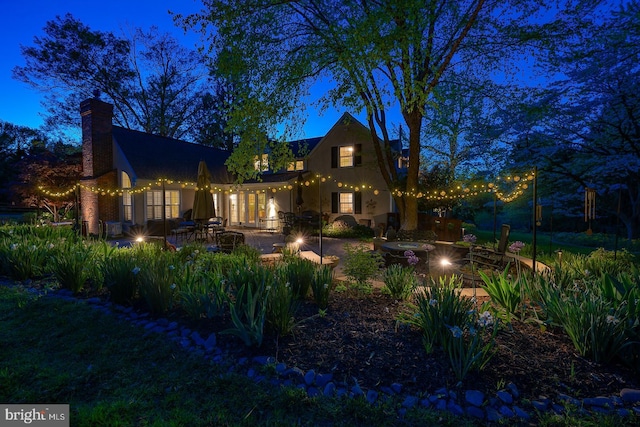 view of front facade with a patio, an outdoor fire pit, and a chimney