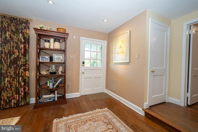 doorway with recessed lighting, baseboards, visible vents, and wood finished floors