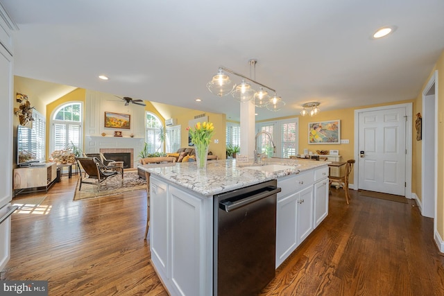 kitchen with plenty of natural light, a ceiling fan, a fireplace, dishwasher, and a sink