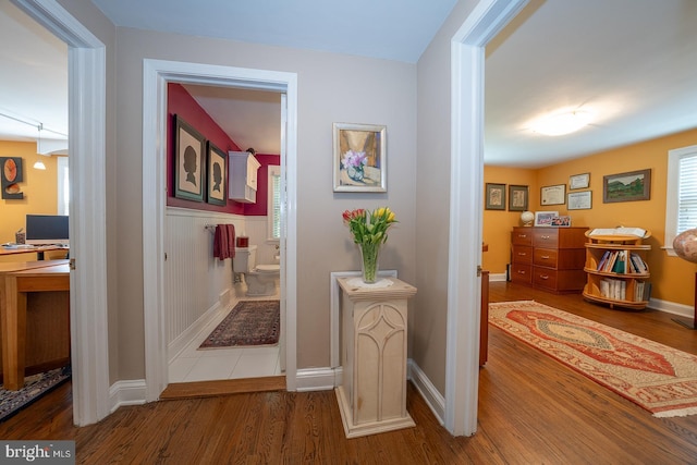 hallway with baseboards and wood finished floors