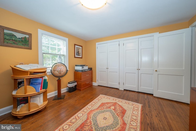 interior space with baseboards and wood finished floors