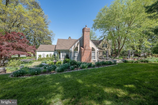 view of side of property featuring a lawn and a chimney
