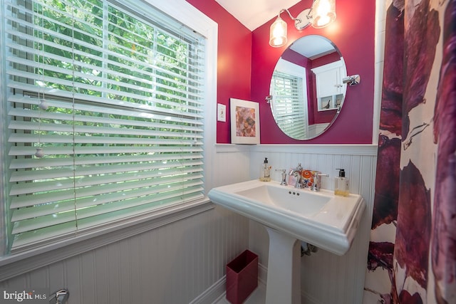 bathroom with a decorative wall and a wainscoted wall