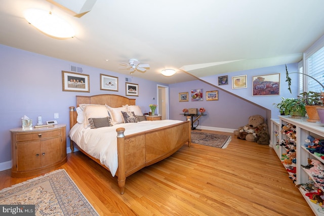 bedroom with light wood-type flooring, a ceiling fan, and baseboards