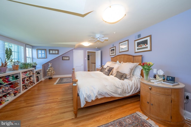 bedroom with a ceiling fan, baseboards, visible vents, and light wood-type flooring