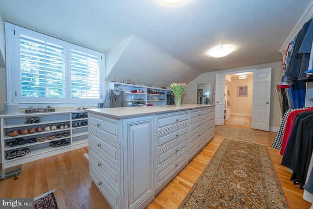 walk in closet featuring light wood-type flooring and lofted ceiling