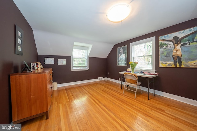 additional living space with visible vents, baseboards, vaulted ceiling, and light wood finished floors