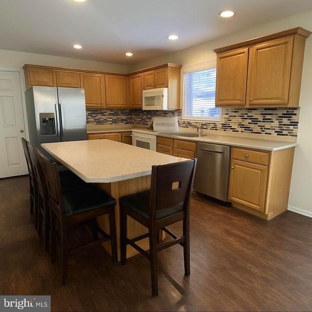 54 Ethel Ave, Hummelstown, PA 17036 - kitchen with stainless steel appliances, light countertops, a breakfast bar, dark wood-type flooring, and tasteful backsplash